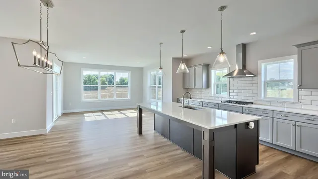 a large kitchen with kitchen island a sink stainless steel appliances and cabinets