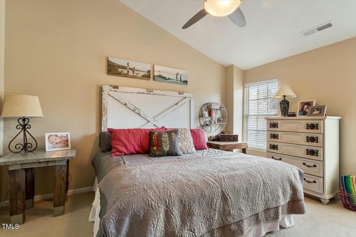 1104 Garnet Ridge Way Raleigh, NC 27607 - Photo 16 of 20 a bedroom with a bed and a chandelier