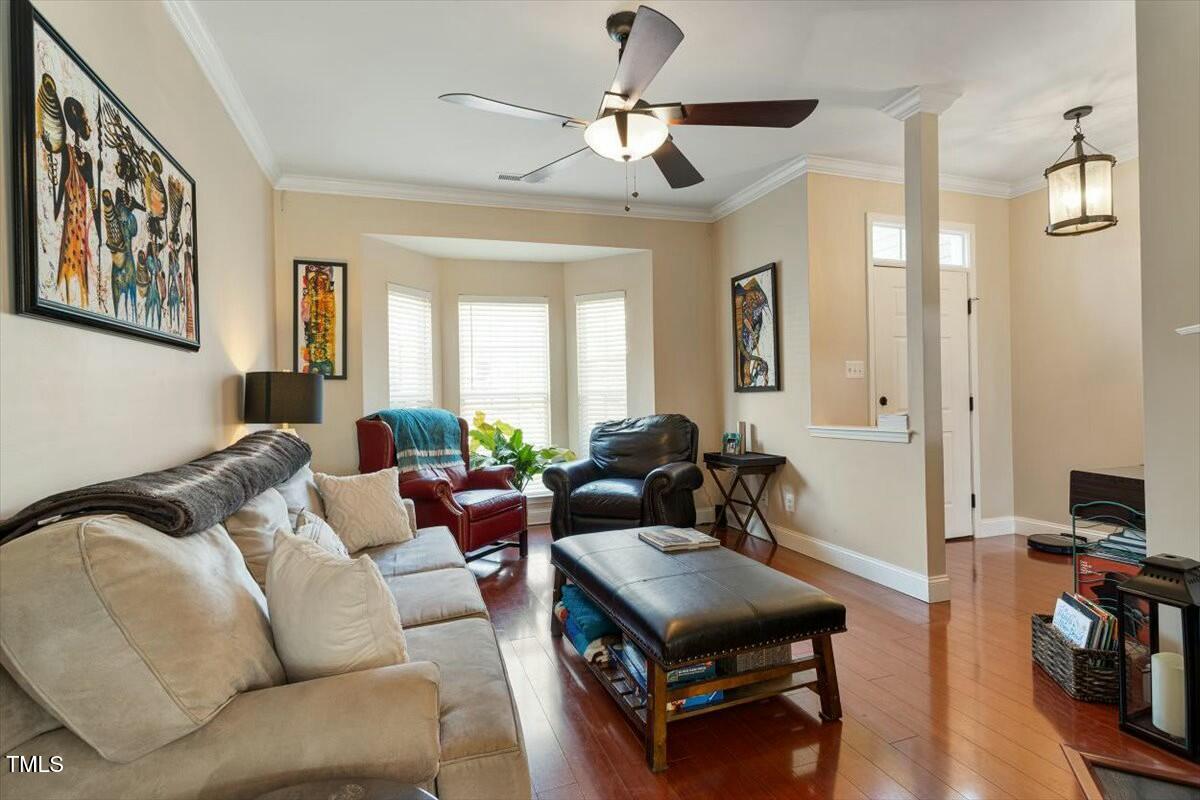 1104 Garnet Ridge Way Raleigh, NC 27607 - Photo 7 of 20 a living room with furniture a ceiling fan and a window