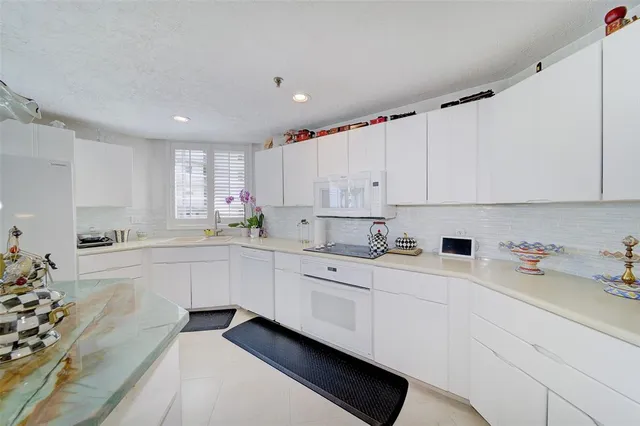 a kitchen with cabinets appliances a sink and a counter top space
