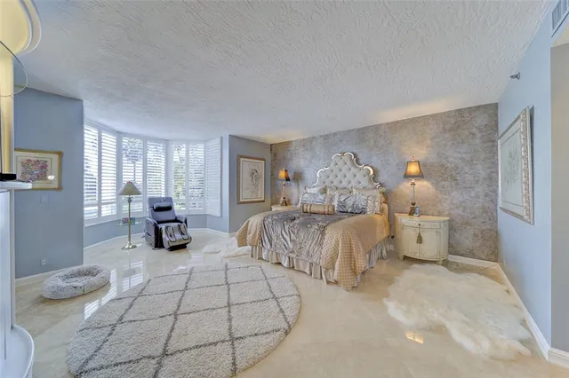 a spacious bedroom with a bed and lamp