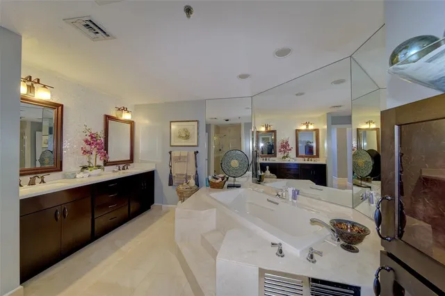 a large white kitchen with a large counter top appliances and cabinets