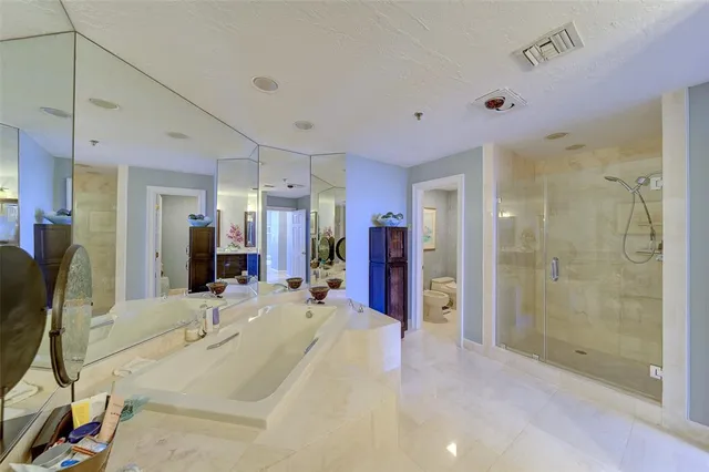 a large bathroom with a granite countertop double vanity sink a mirror and a bathtub