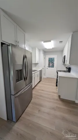 a kitchen with stainless steel appliances a refrigerator sink and microwave