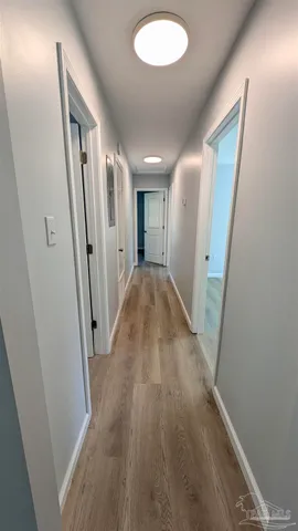 a view of a hallway with wooden floor and staircase