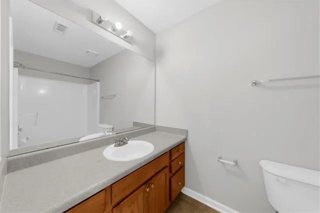 a bathroom with a sink toilet vanity and mirror