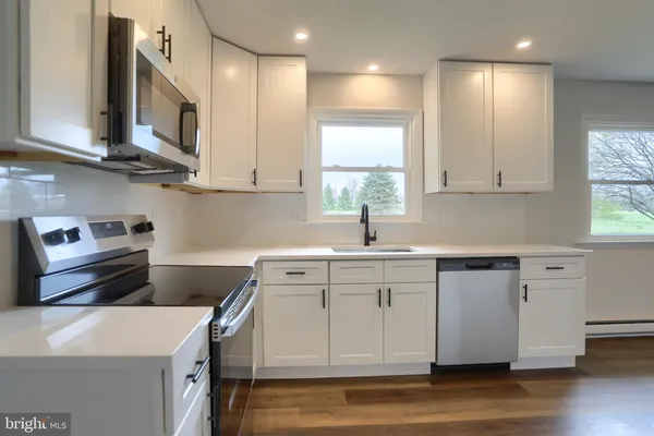 a kitchen with a sink cabinets and wooden floor