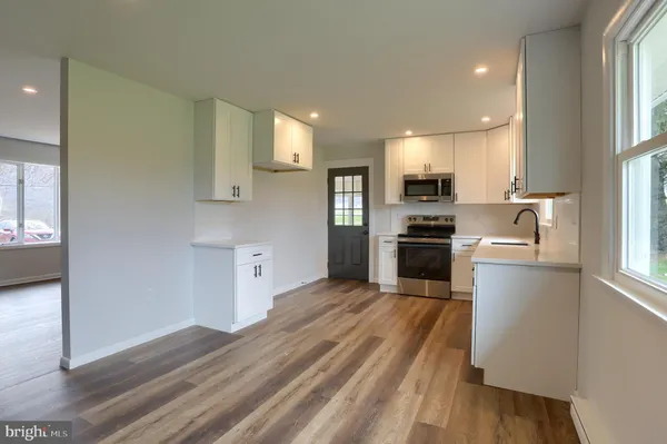 a kitchen with a refrigerator and a stove top oven