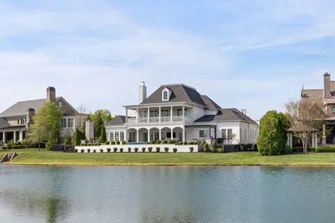 a view of swimming pool with outdoor seating and house in the background