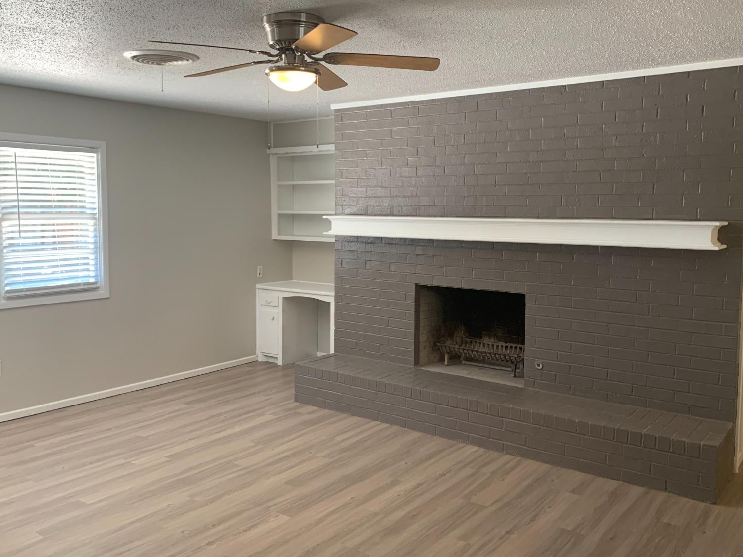 4316 58th Street, Unit A Lubbock, TX 79413 - Photo 2 of 10 a view of an empty room with a fireplace and a window