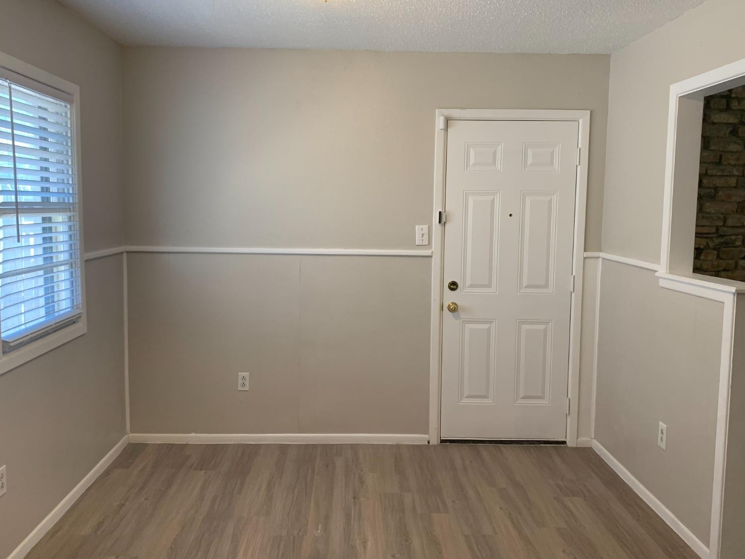 4316 58th Street, Unit A Lubbock, TX 79413 - Photo 5 of 10 an empty room with wooden floor and windows