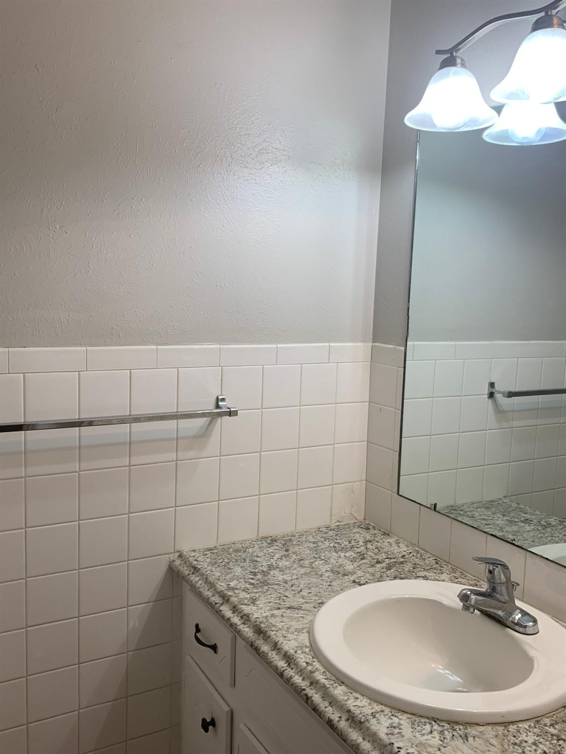 4316 58th Street, Unit A Lubbock, TX 79413 - Photo 7 of 10 a bathroom with a sink and a mirror