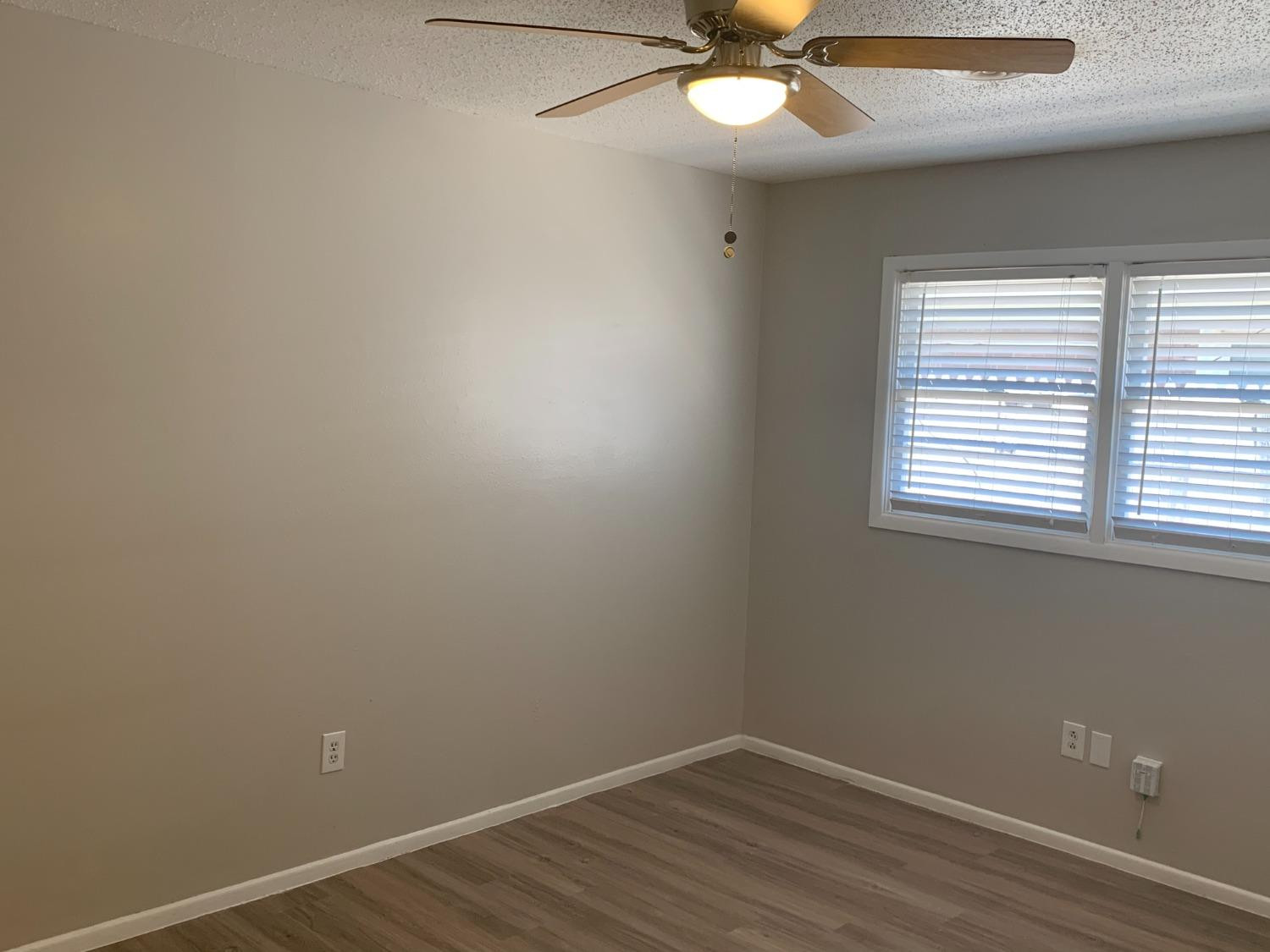 4316 58th Street, Unit A Lubbock, TX 79413 - Photo 8 of 10 an empty room with a window and a fan