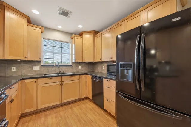 a kitchen with stainless steel appliances granite countertop a sink and a white cabinets