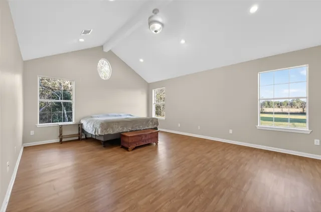 a spacious bedroom with a bed and a window