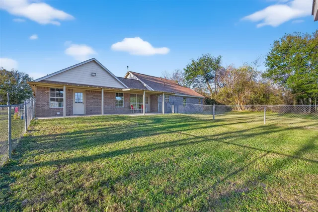 a front view of house with outdoor space and trees in the background
