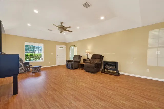 a living room with furniture and a flat screen tv with wooden floor