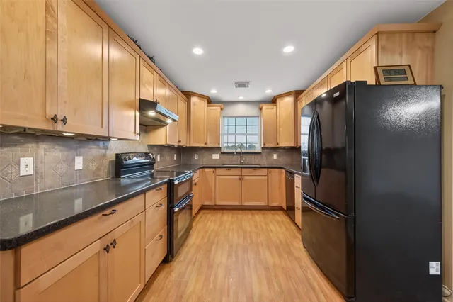 a kitchen with stainless steel appliances granite countertop a sink a stove and a microwave