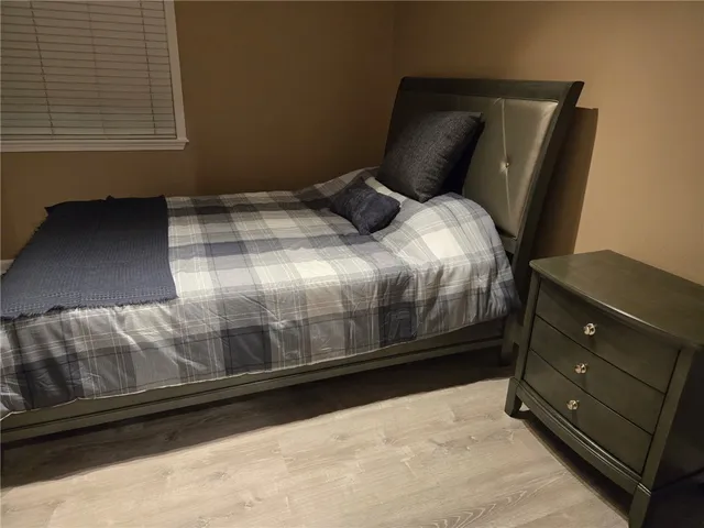 a bedroom with a bed and a night stand