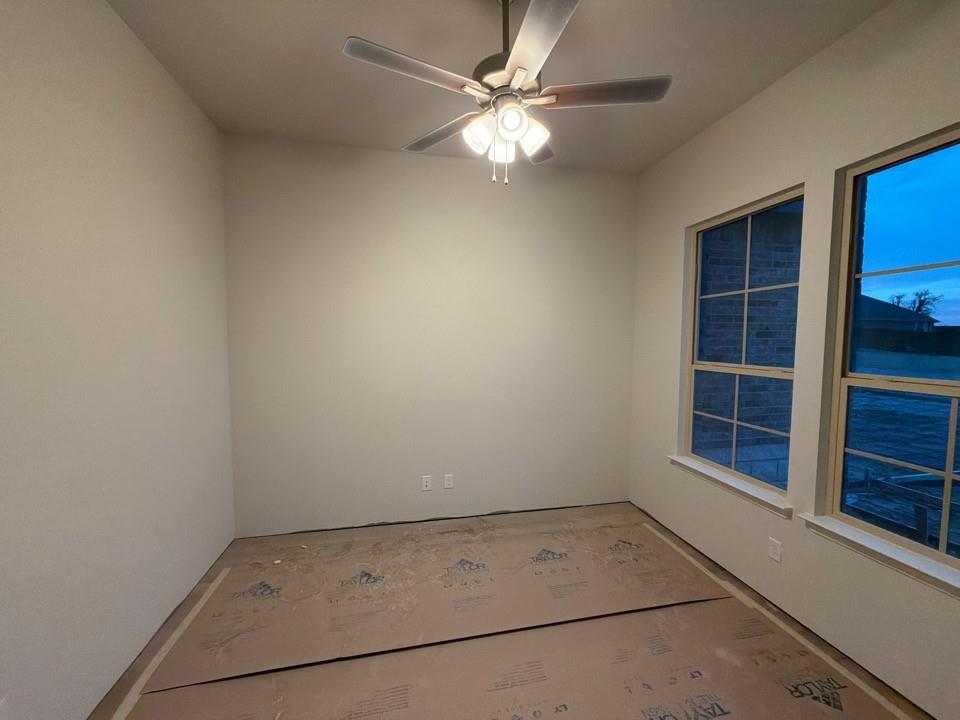 1132 Trinity Drive Springtown, TX 76082 - Photo 3 of 11 an empty room with a chandelier fan and windows