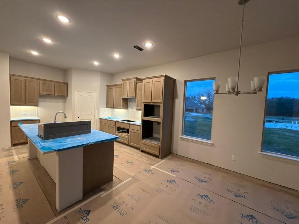 1132 Trinity Drive Springtown, TX 76082 - Photo 6 of 11 a kitchen with stainless steel appliances kitchen island granite countertop a sink refrigerator and cabinets
