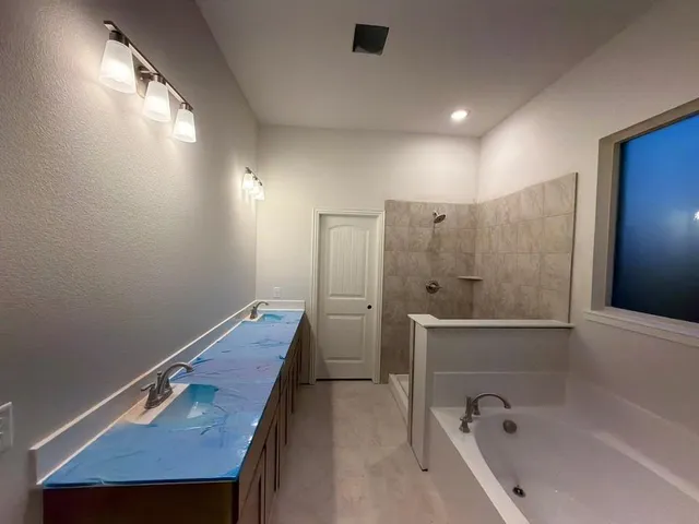 a bathroom with a tub a sink and mirror