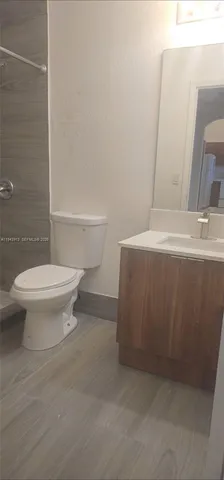 a bathroom with a toilet a sink and shower