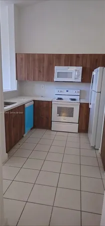 a kitchen with granite countertop a stove a sink and a microwave