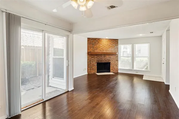 a view of a livingroom with wooden floor and a fireplace