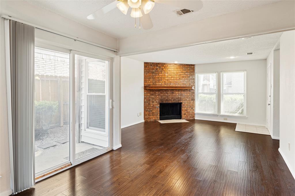 a view of a livingroom with wooden floor and a fireplace