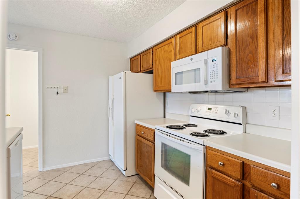 7591 Tournament Road Frisco, TX 75035 - Photo 12 of 26 a kitchen with stainless steel appliances granite countertop a stove a refrigerator and a cabinets