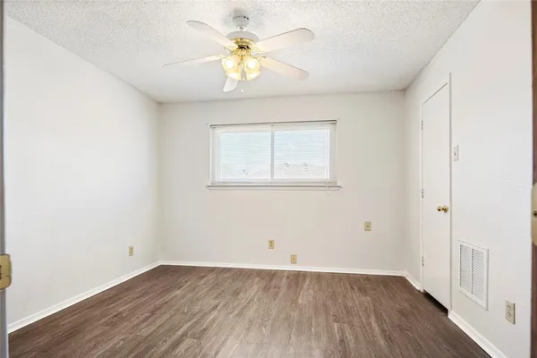 an empty room with a window and wooden floor