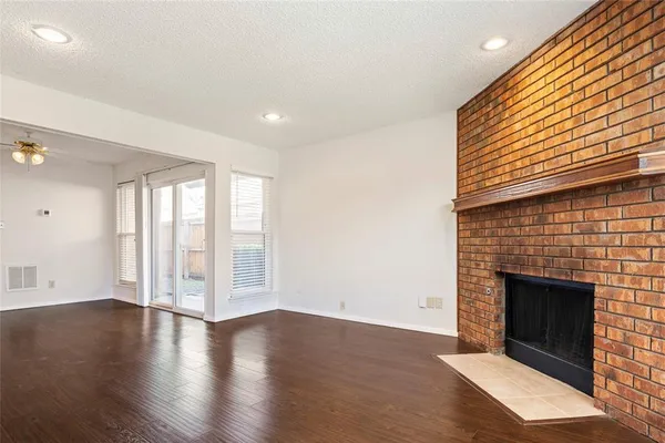 an empty room with wooden floor and fireplace