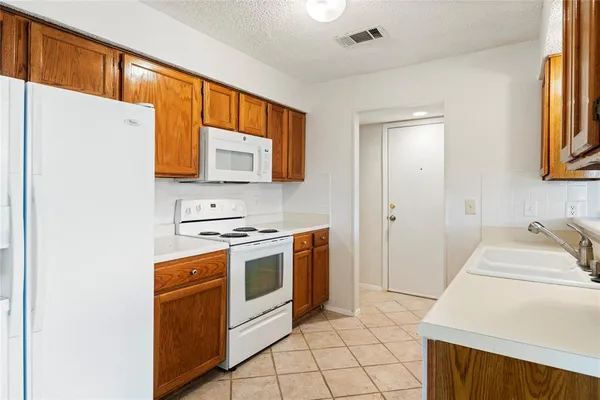 a kitchen with granite countertop a sink stove and refrigerator