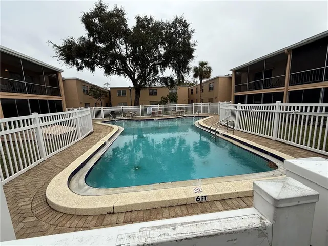 a view of a roof deck with couches chairs and wooden fence