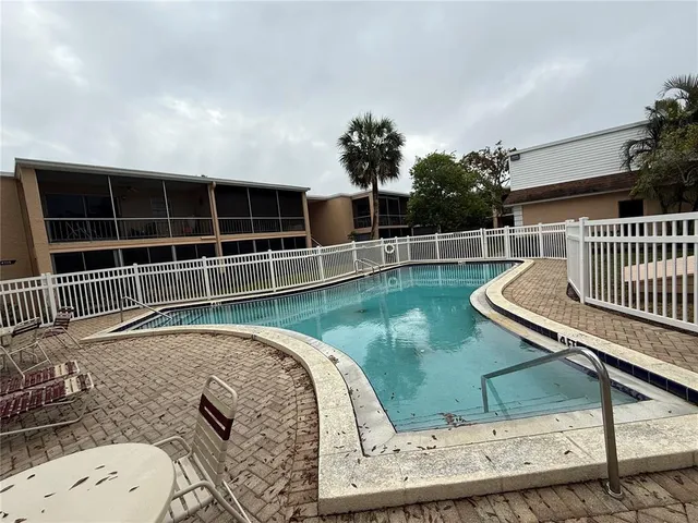 a view of a backyard with couches chair with wooden floor and fence