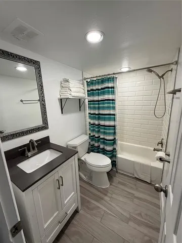 a bathroom with a granite countertop sink toilet a mirror and shower