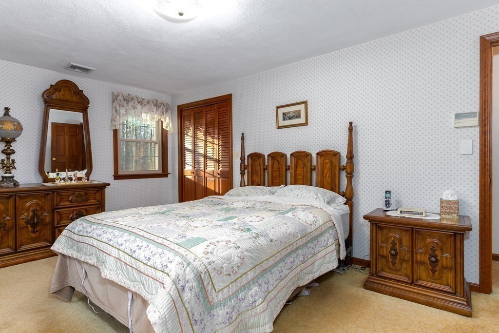 1920 Maple Street Dighton, MA 02764 - Photo 23 of 42 a bedroom with a bed and dresser with mirror