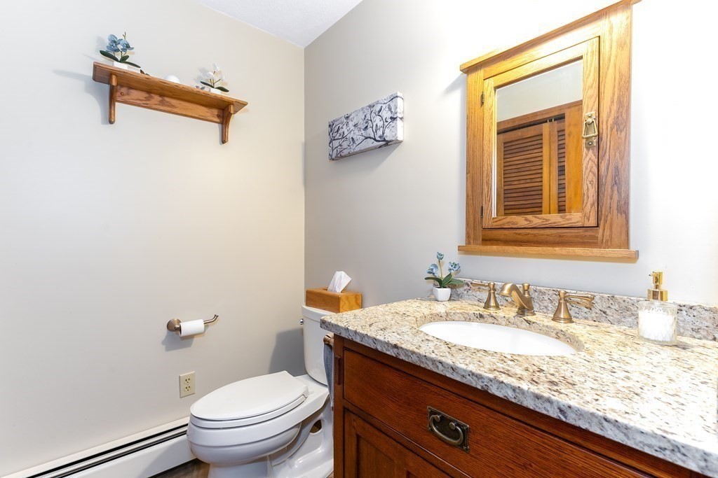 1920 Maple Street Dighton, MA 02764 - Photo 31 of 42 a bathroom with a granite countertop sink a toilet and a mirror