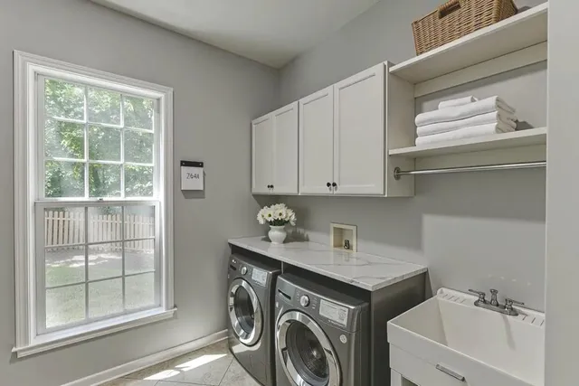 a spacious bathroom with a double vanity sink a large mirror and shower
