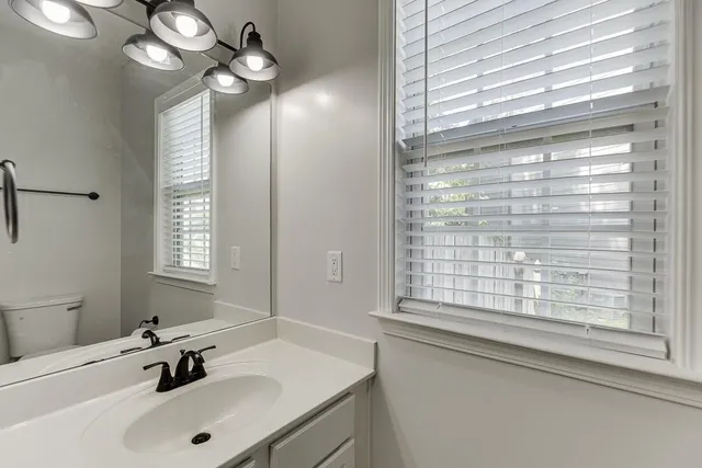 a large white kitchen with a sink and refrigerator