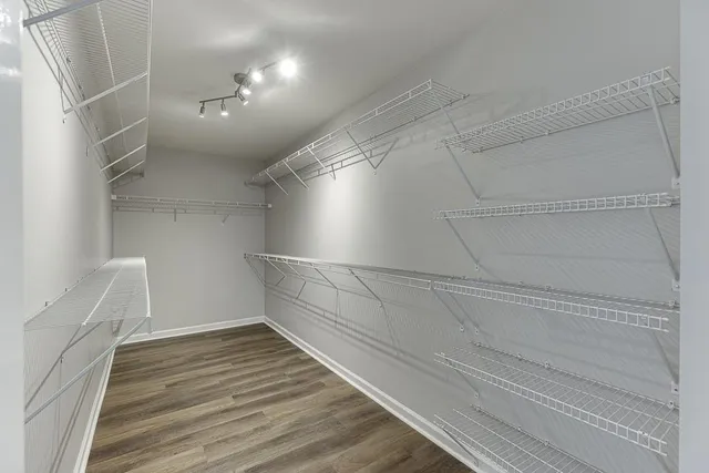 an empty room with a fan & a window