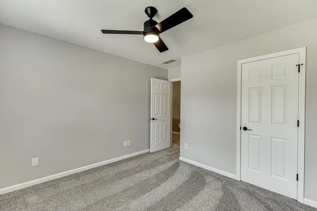 an empty room with closet and windows