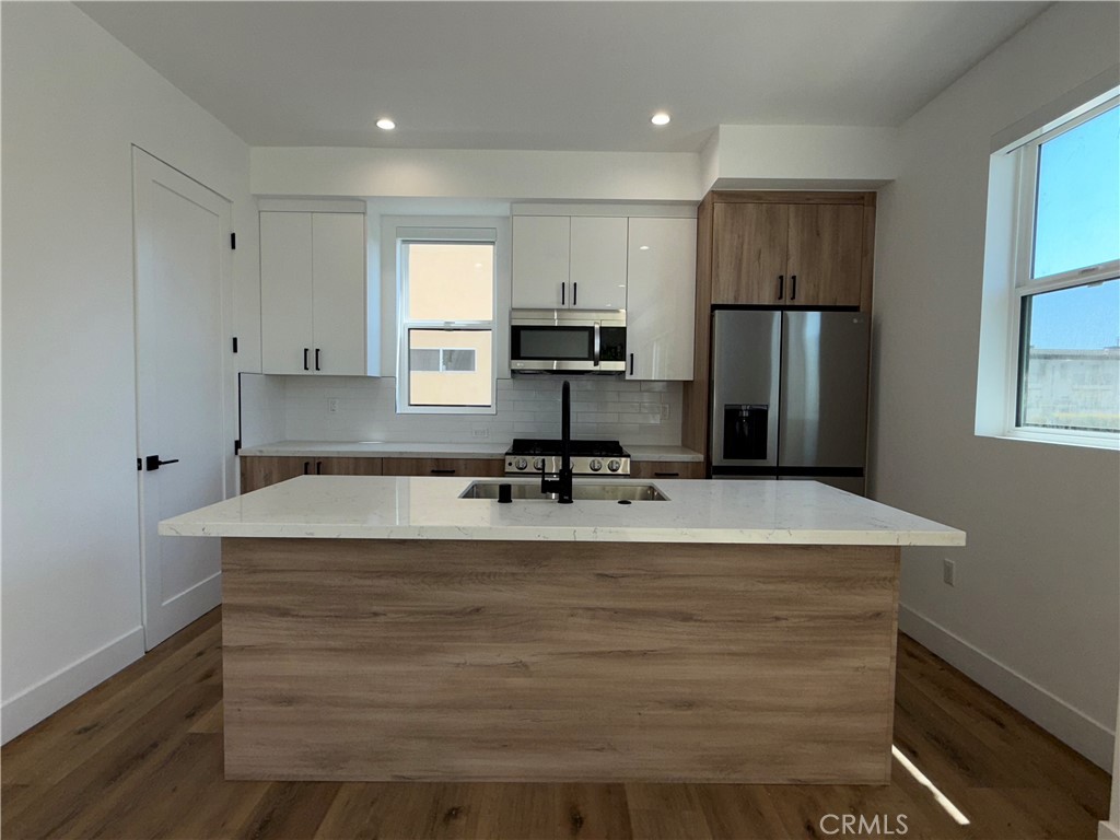 a view of kitchen with refrigerator stove and wooden cabinets