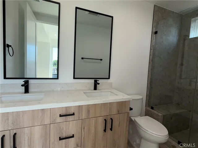 a bathroom with a toilet sink vanity and mirror