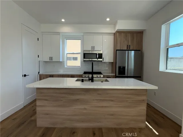 a view of kitchen with refrigerator stove and wooden cabinets