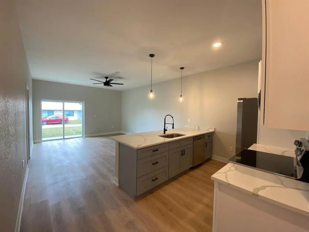 10524 Pendleton Avenue Englewood, FL 34224 - Photo 2 of 12 a kitchen that has a lot of cabinets in it and wooden floor