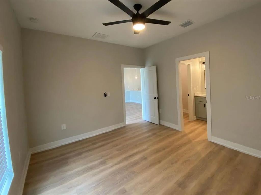10524 Pendleton Avenue Englewood, FL 34224 - Photo 4 of 12 wooden floor in an empty room with a window