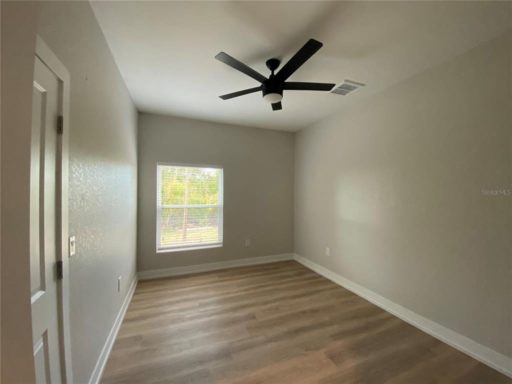 10524 Pendleton Avenue Englewood, FL 34224 - Photo 9 of 12 a view of a big room with wooden floor a ceiling fan and windows