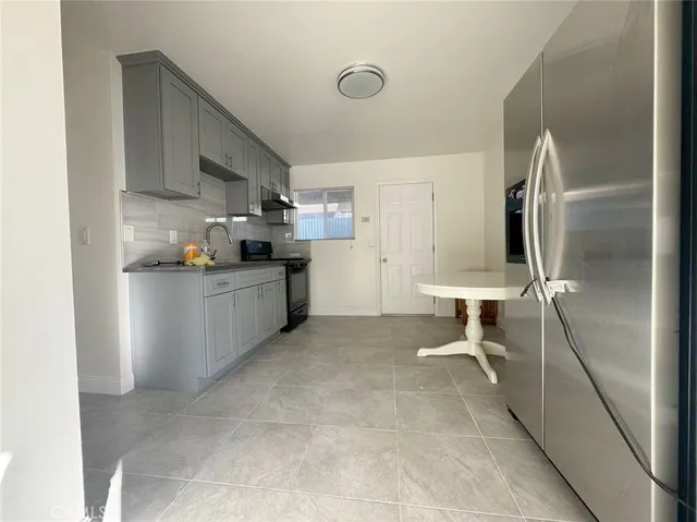 a kitchen with granite countertop a sink stove and refrigerator